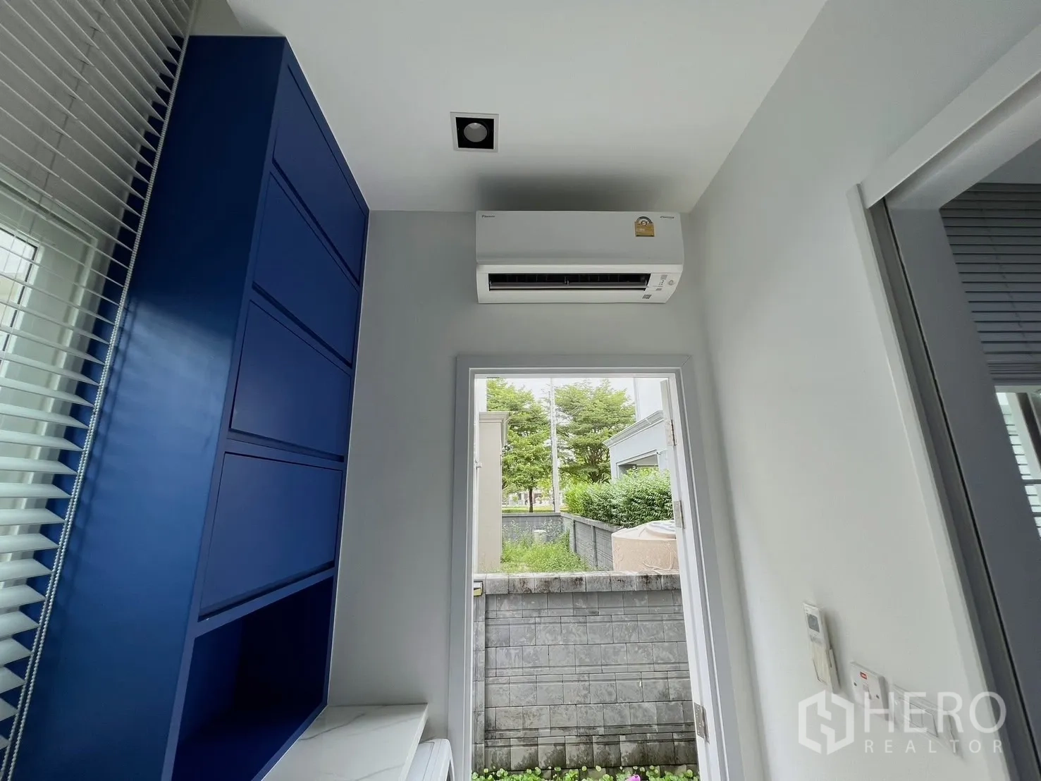 Detached House for rent or sale in Khlong Luang, Pathum Thani - Laundry or utility zone with blue cabinets, air-conditioner and door to garden.