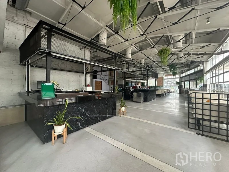 Retail Space for rent in Watthana, Bangkok - Black marble service kiosk under industrial ceiling with hanging greenery.
