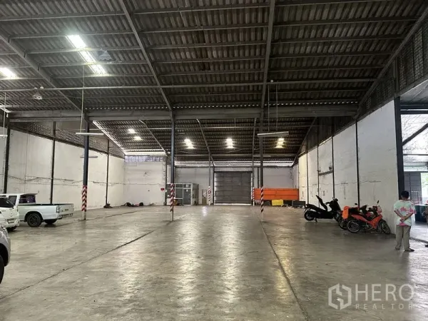 Warehouse for rent in Khan Na Yao, Bangkok - Deep warehouse hall featuring steel trusses, ventilation blocks and a wide central aisle.