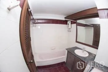 Condominium for sale in Watthana, Bangkok - Tiled bathroom featuring a bathtub, stone-top vanity and large mirror.