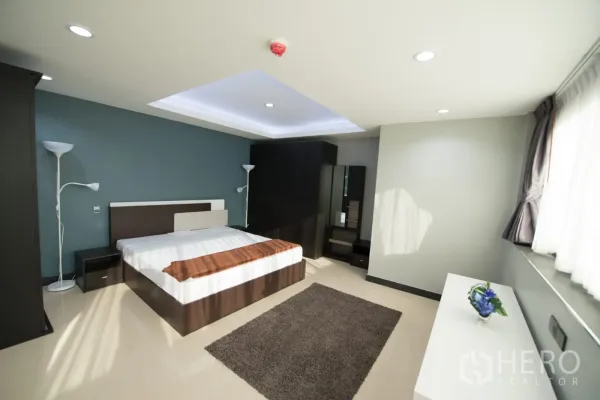 公寓 出租或出售在Khlong Toei, Bangkok - 主卧另一视角，带大窗、地毯与梳妆台储物柜。