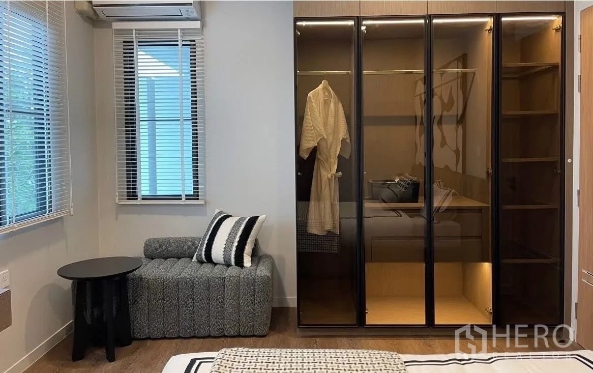 Detached House for rent in Bang Phli, Samut Prakan - Bedroom corner with armchair and illuminated glass-door wardrobe.