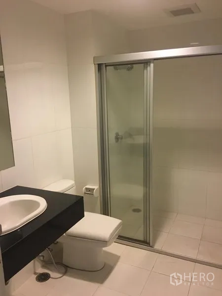 公寓 出租或出售在Watthana, Bangkok - 第二浴室设玻璃淋浴间、马桶和现代台盆柜。