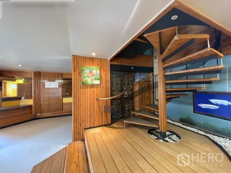 Condominium for rent or sale in Suan Luang, Bangkok - Expansive open-plan area featuring a spiral wooden staircase and raised platform.