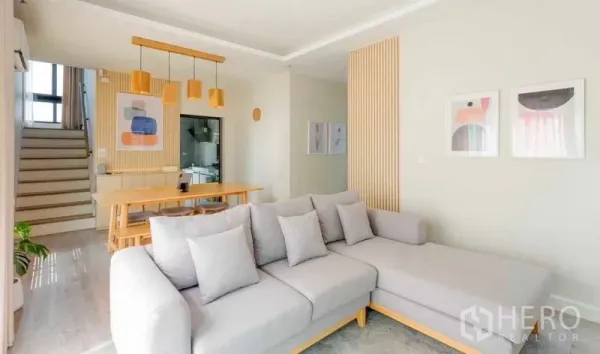 บ้าน ให้เช่าในBang Khun Thian, Bangkok - โถงนั่งเล่นและทานอาหารแบบโอเพ่นแปลน โซฟาสีเทา โต๊ะไม้ และโคมไฟแขวน