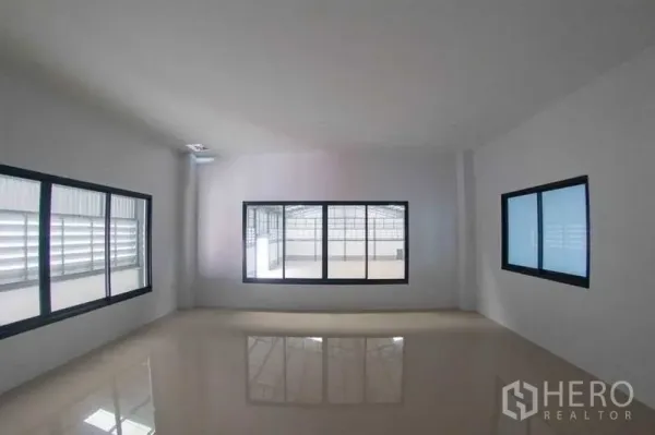 Warehouse for rent in Mueang Pathum Thani, Pathum Thani - Bright upper-floor room with large windows and glossy tiled floor in the office-residence area.
