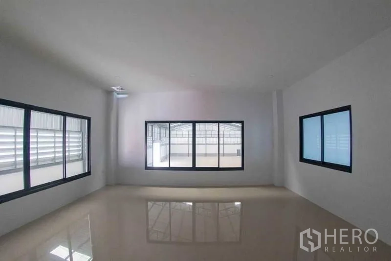 Warehouse for rent in Mueang Pathum Thani, Pathum Thani - Bright upper-floor room with large windows and glossy tiled floor in the office-residence area.
