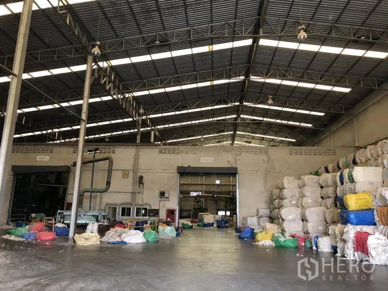 โรงงาน ให้เช่าในBang Bua Thong, Nonthaburi - ฮอลล์อุตสาหกรรมพื้นคอนกรีต มีอุปกรณ์ดับเพลิงและกองวัสดุจัดเป็นระเบียบ