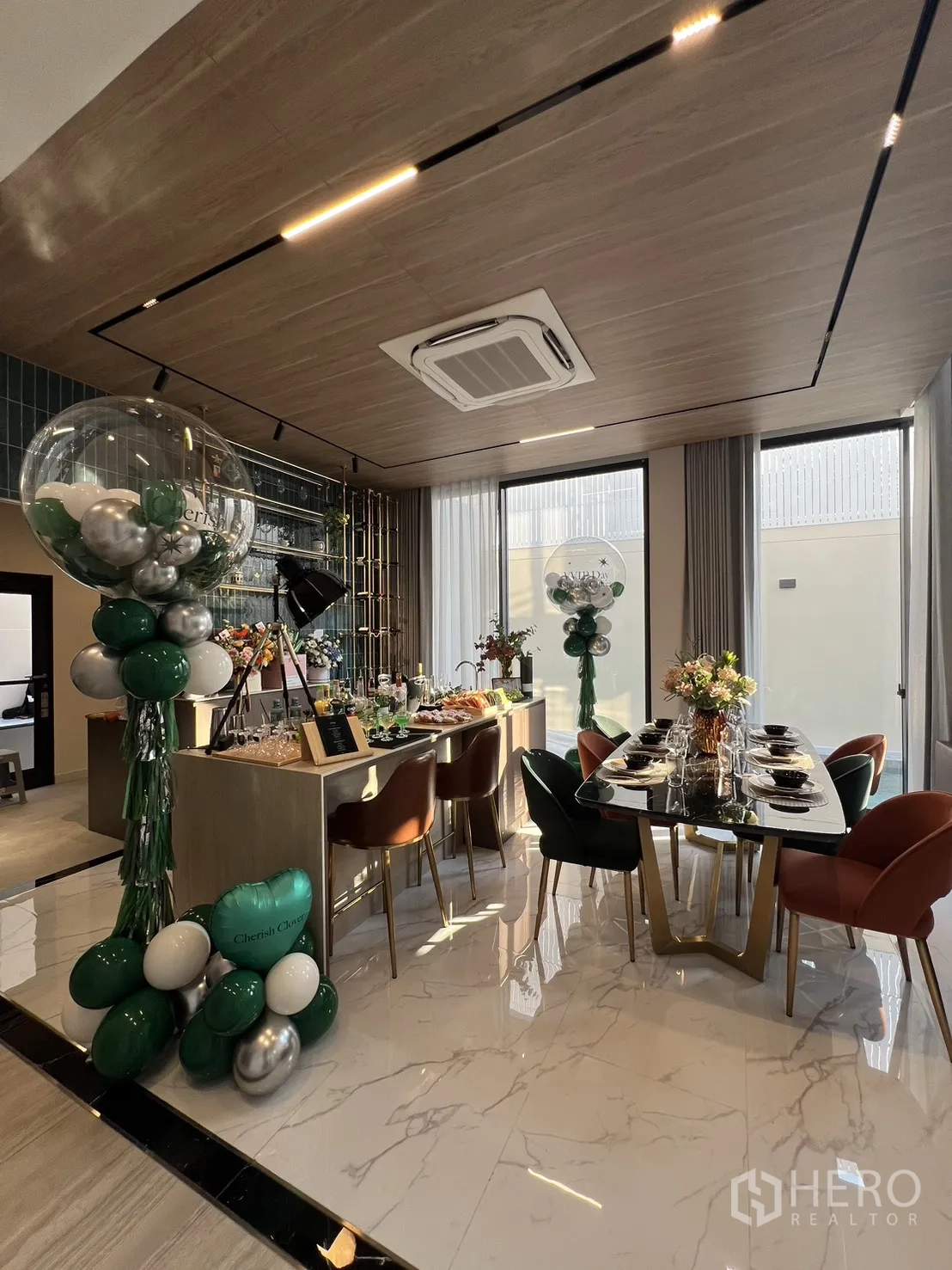 Detached House for sale in Lat Phrao, Bangkok - Open kitchen with island breakfast bar and formal dining under a wood ceiling.