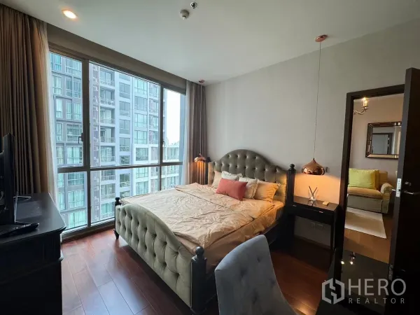 公寓 出租在Watthana, Bangkok - 采光充足的卧室，软包床与吊灯，大窗户面向邻近楼宇。
