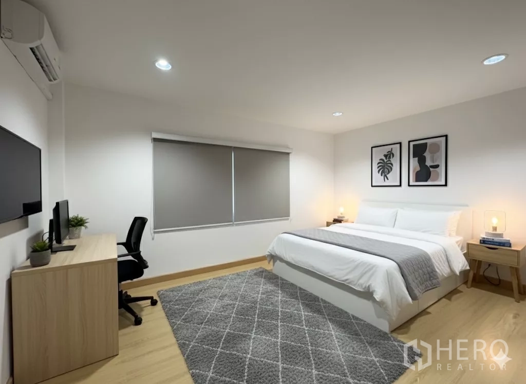 บ้าน ให้เช่า - ห้องนอนกว้าง มีโต๊ะทำงาน ทีวี และพรมสีเทา.