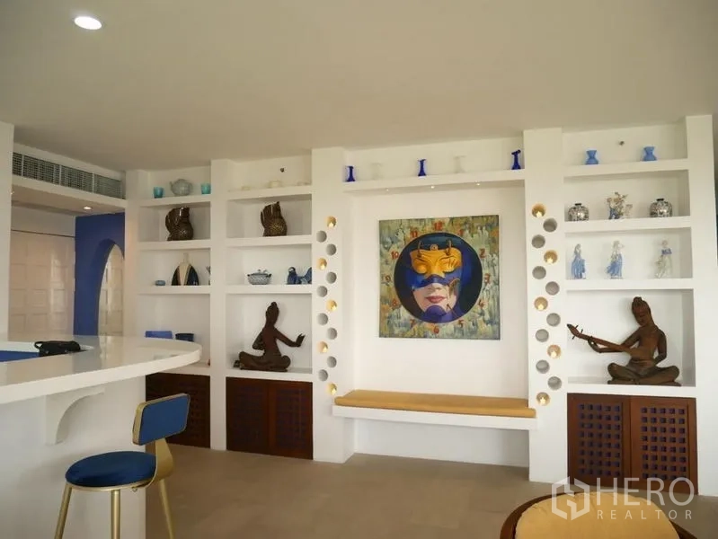 Condominium for rent in Khlong Toei, Bangkok - Feature wall with built-in display shelves and contemporary art.
