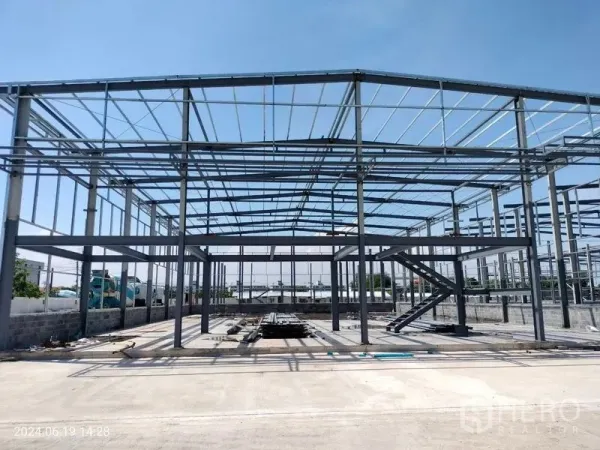 货栈 出租在Samut Prakan - 双跨钢架仓库正立面，设中央楼梯与开放式楼面。