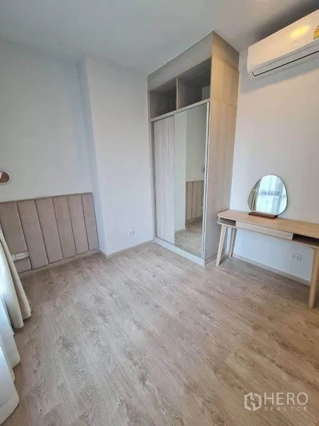 Condominium for rent - Second bedroom with mirrored wardrobe, compact vanity and air conditioner.