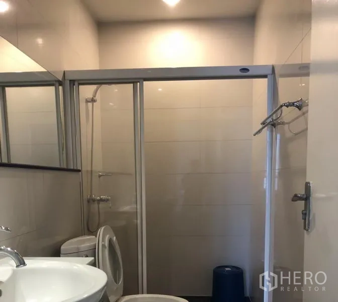 公寓 出租在Pathum Wan, Bangkok - 浴室配推拉玻璃淋浴间、盥洗台，室内洗衣机。