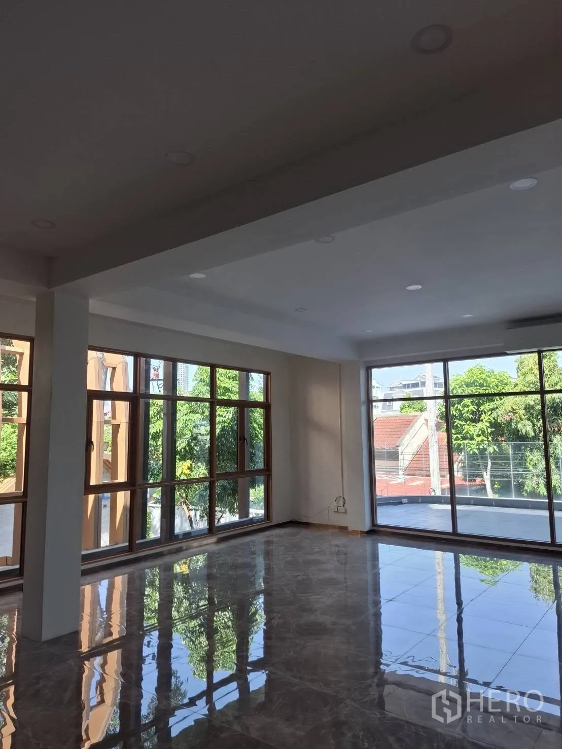 Retail Space for rent in Watthana, Bangkok - Bright upper-level showroom with floor-to-ceiling windows and glossy tile floors opening to a terrace.
