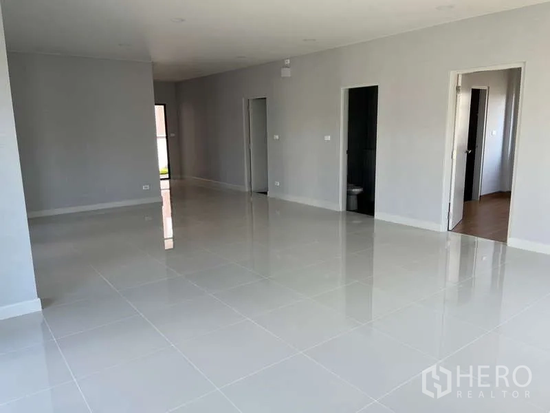 Detached House for rent in Bang Phli, Samut Prakan - Spacious open-plan ground floor with glossy white tiles and multiple room entrances.