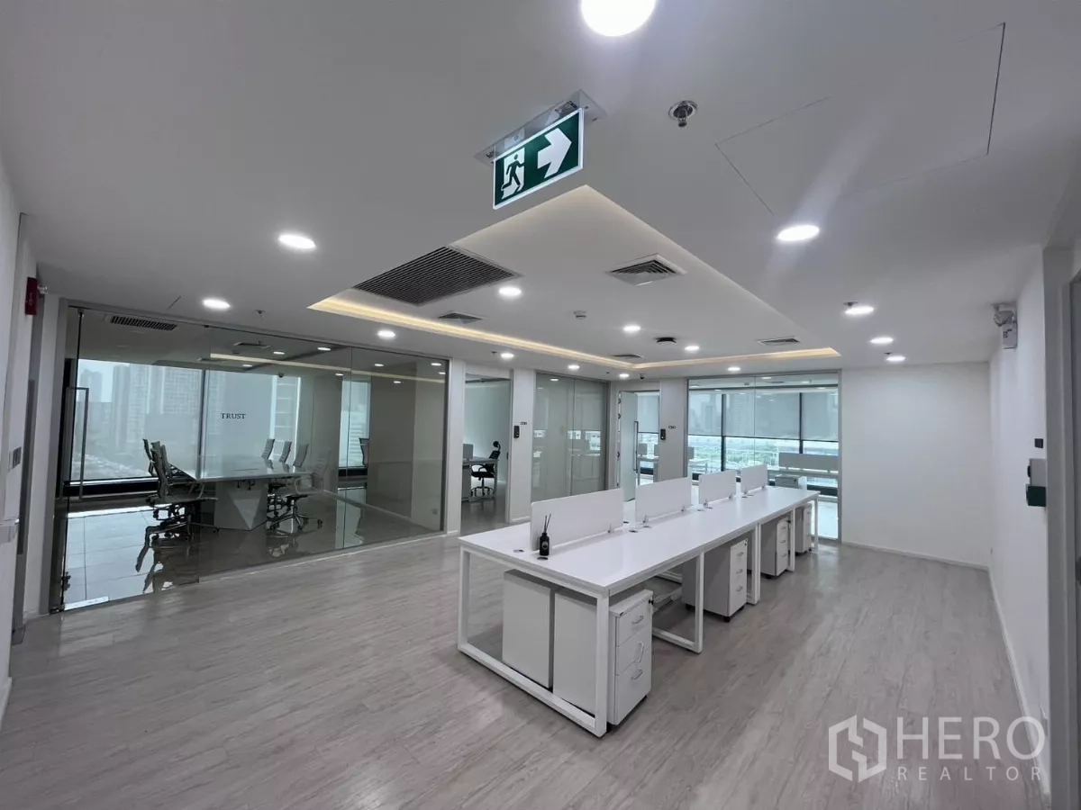 办公空间 出租在Din Daeng, Bangkok - 宽阔视角的明亮办公室，左右为玻璃会议室，落地窗可见城市景色。