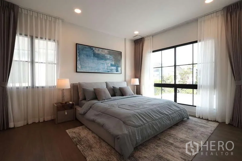 Detached House for rent in Saphan Sung, Bangkok - Spacious master bedroom with corner windows, sheer drapes and soft natural light.