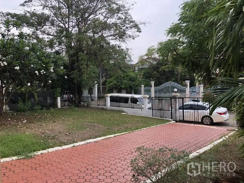 บ้าน ให้เช่า - ลานหน้าบ้านปูทางเดินอิฐสีแดง สนามหญ้าและรั้วประตูทางเข้า