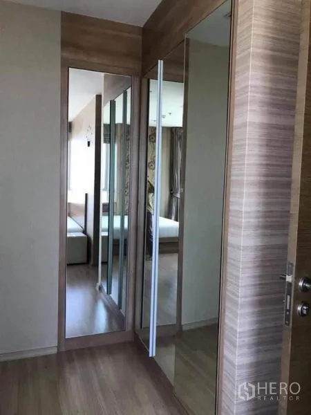 Condominium for rent or sale in Phaya Thai, Bangkok - Hallway with full-height mirrored closets and warm wood finishes.