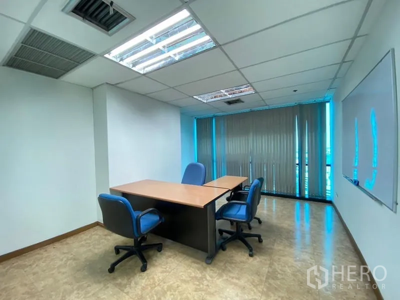 Office Space for rent - Private manager’s office with meeting table, chairs and floor-to-ceiling vertical blinds.