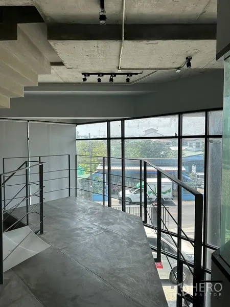 带办公室的家 出租或出售在Prawet, Bangkok - 夹层工作区，大面积玻璃幕墙俯瞰社区景观。