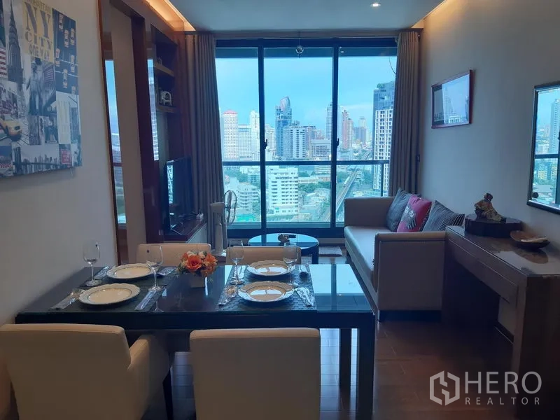 Condominium for rent in Khlong Toei, Bangkok - Open-plan living and dining area with floor-to-ceiling windows and panoramic Bangkok skyline view.