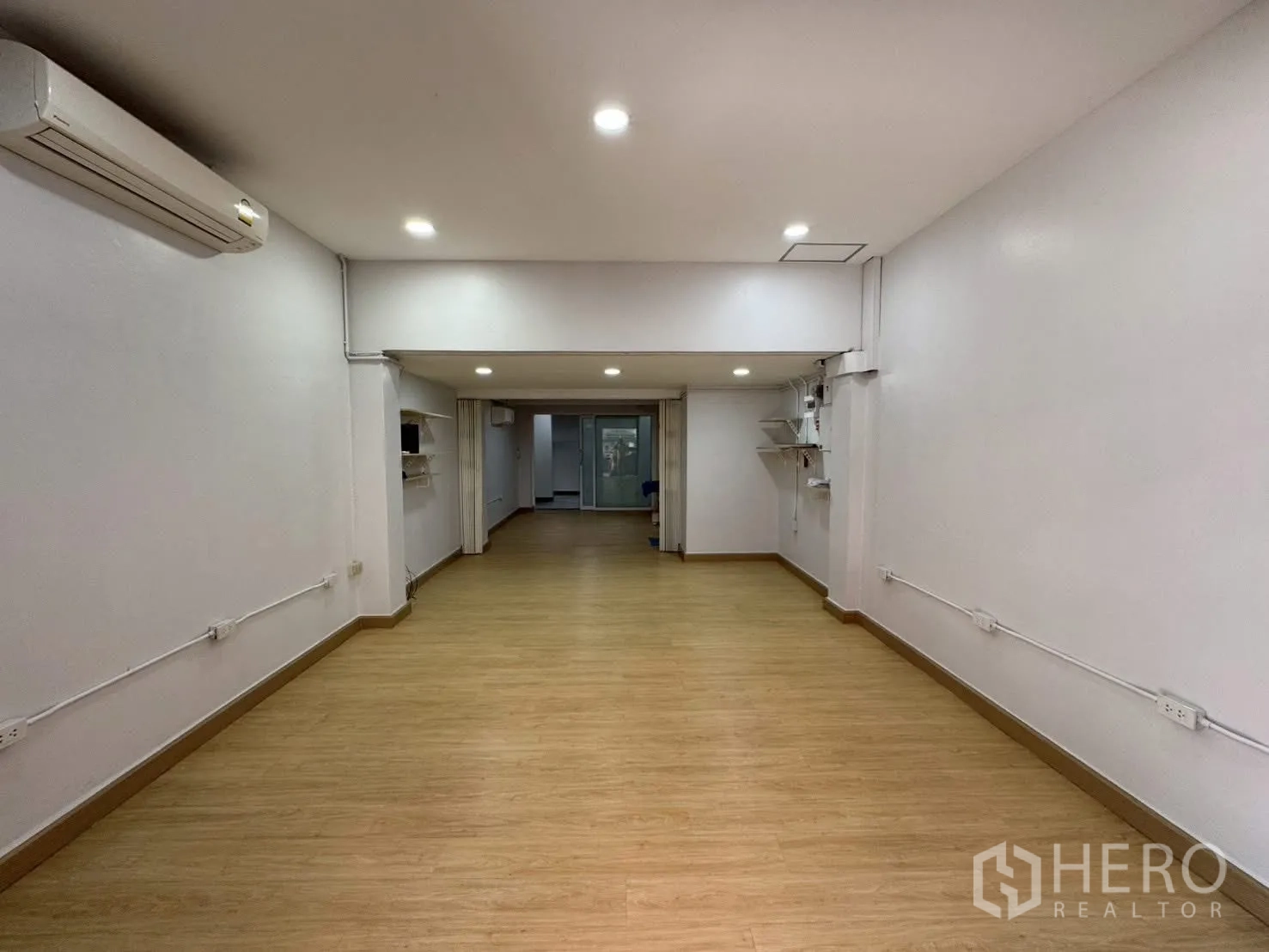 Home Office for rent in Sathon, Bangkok - Ground-floor open area with wood flooring, downlights, and air conditioning.