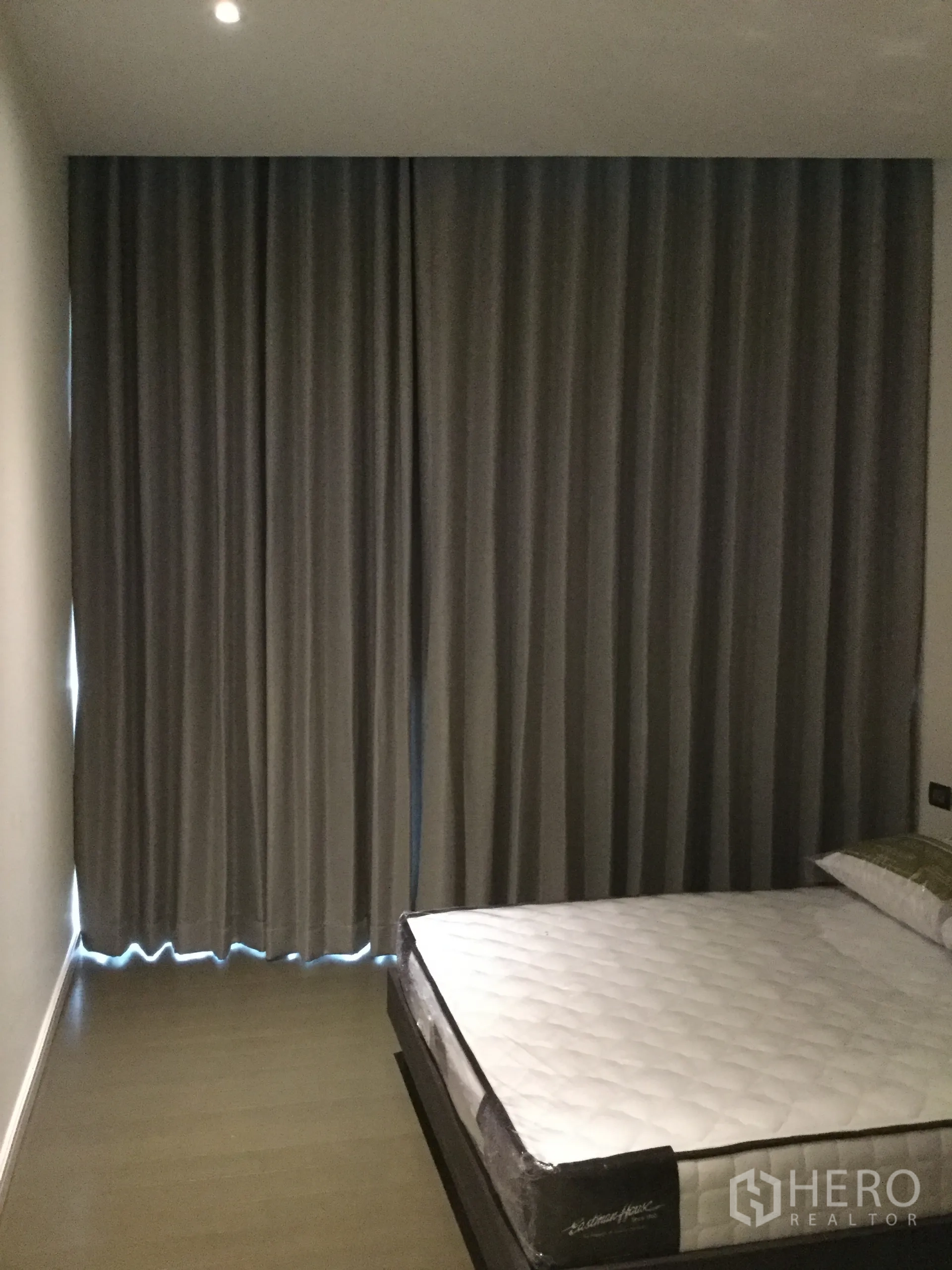 公寓 出租在Pathum Wan, Bangkok - 卧室配平台床与遮光窗帘，筒灯与木地板舒适温馨。