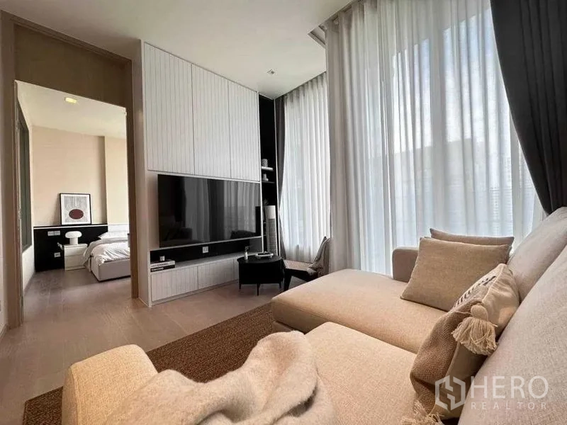 公寓 出租在Watthana, Bangkok - 客厅通向卧室，电视背景墙与全高窗帘