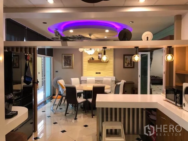 Detached House for sale in Wang Thonglang, Bangkok - Dining area with round table, accent ceiling lights and a view toward the kitchen.