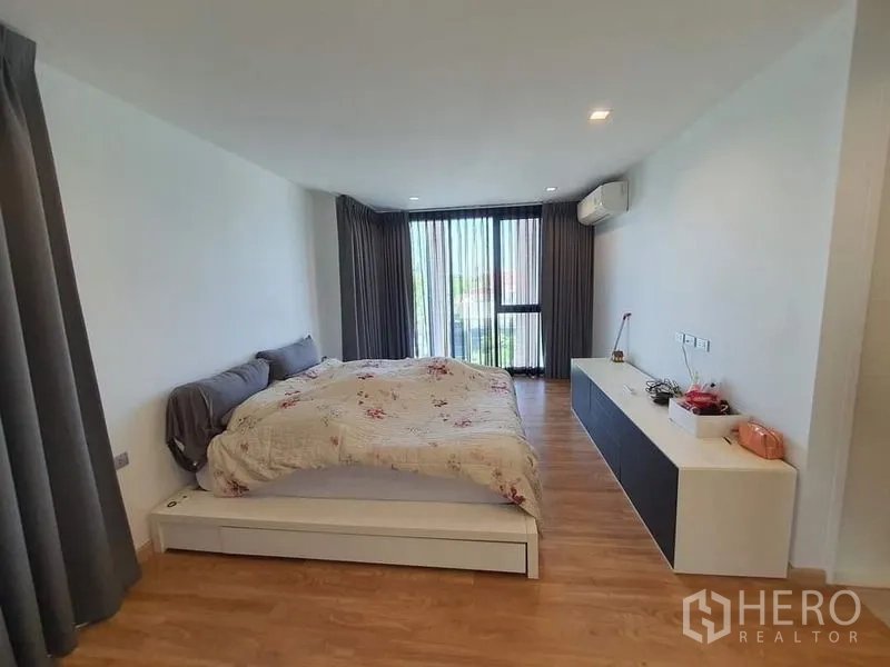 联排别墅 出售在Lat Phrao, Bangkok - 次卧采光好，带阳台窗与木地板、内置电视柜。