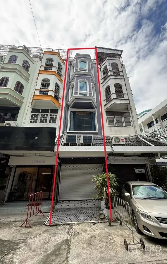 店屋 出租 - 五层店屋外观，带凸窗与卷闸门，在一排建筑中以红线标注。