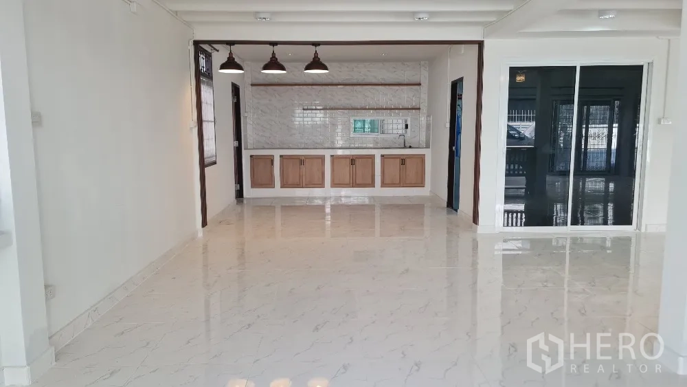 Detached House for rent in Lat Phrao, Bangkok - Enclosed Thai kitchen with tiled walls, built-in counters, sink and wooden cabinets.