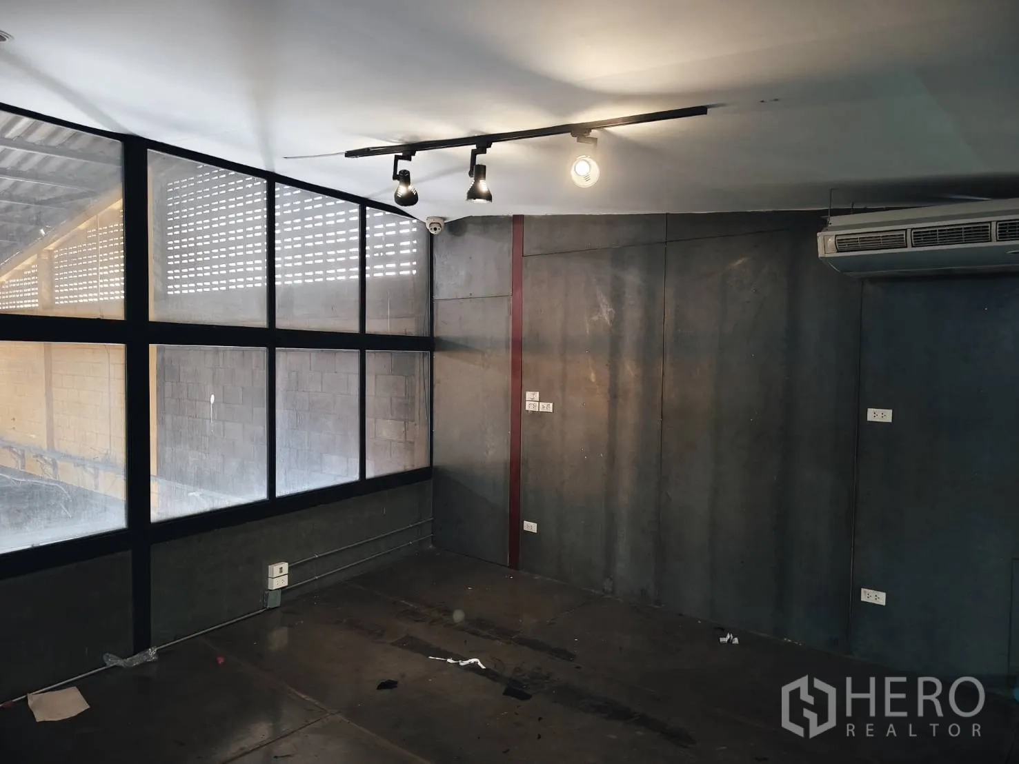 货栈 出租在Khlong Toei, Bangkok - 转角办公室，大窗、轨道灯与深色抛光地面。