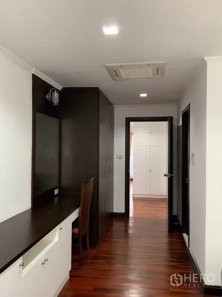 公寓 出租在Watthana, Bangkok - 走廊与卧室区，内置衣柜、长梳妆书桌与筒灯照明。