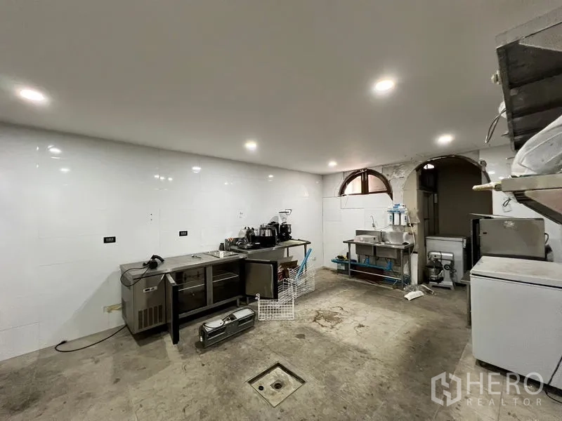 Shophouse for rent in Watthana, Bangkok - White-tiled back-of-house room with sinks, stainless counters, and equipment.