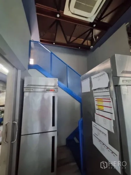Retail Space for rent in Bang Rak, Bangkok - Storage area with double-door fridges and blue stairs to mezzanine.