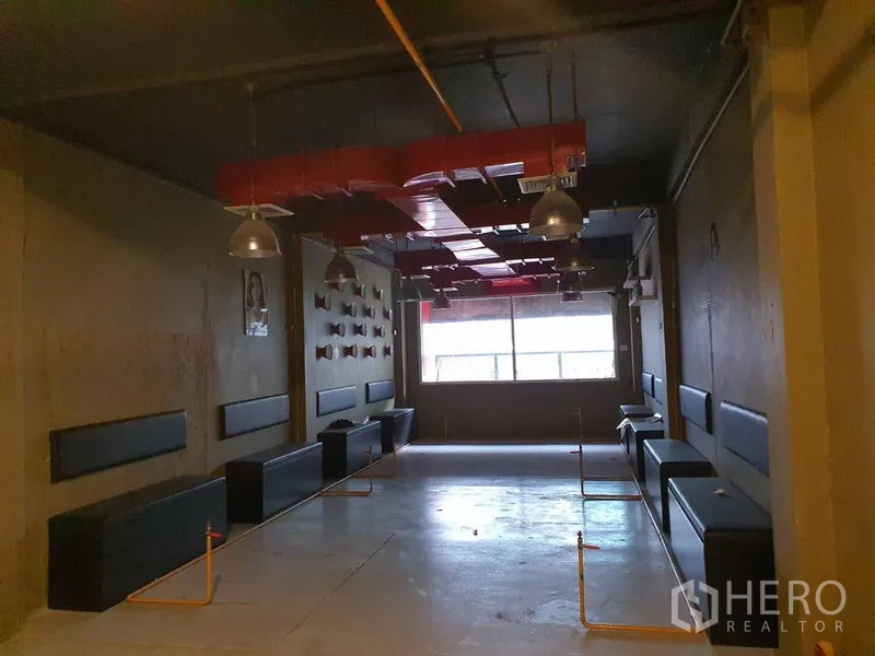 Shophouse for rent in Khlong Toei, Bangkok - Spacious upper level with bench seating along the walls, industrial pendant lights and red ductwork.