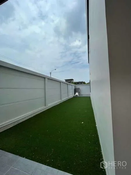 Home Office for rent in Khan Na Yao, Bangkok - Private side garden with artificial turf running along the boundary wall.