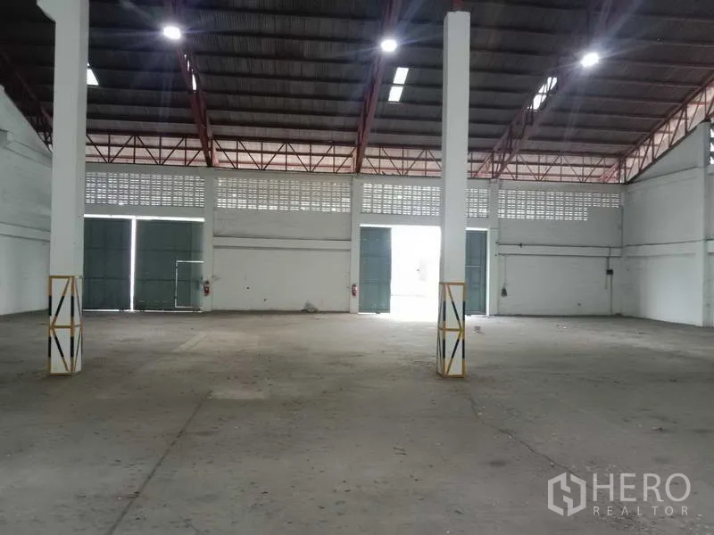 Factory for rent in Samut Prakan - Wide-span hall with multiple bay doors and skylights for natural light.