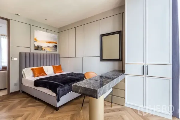Condominium for rent in Khlong Toei, Bangkok - Stylish bedroom with upholstered headboard, built-in wardrobes and marble-topped vanity.