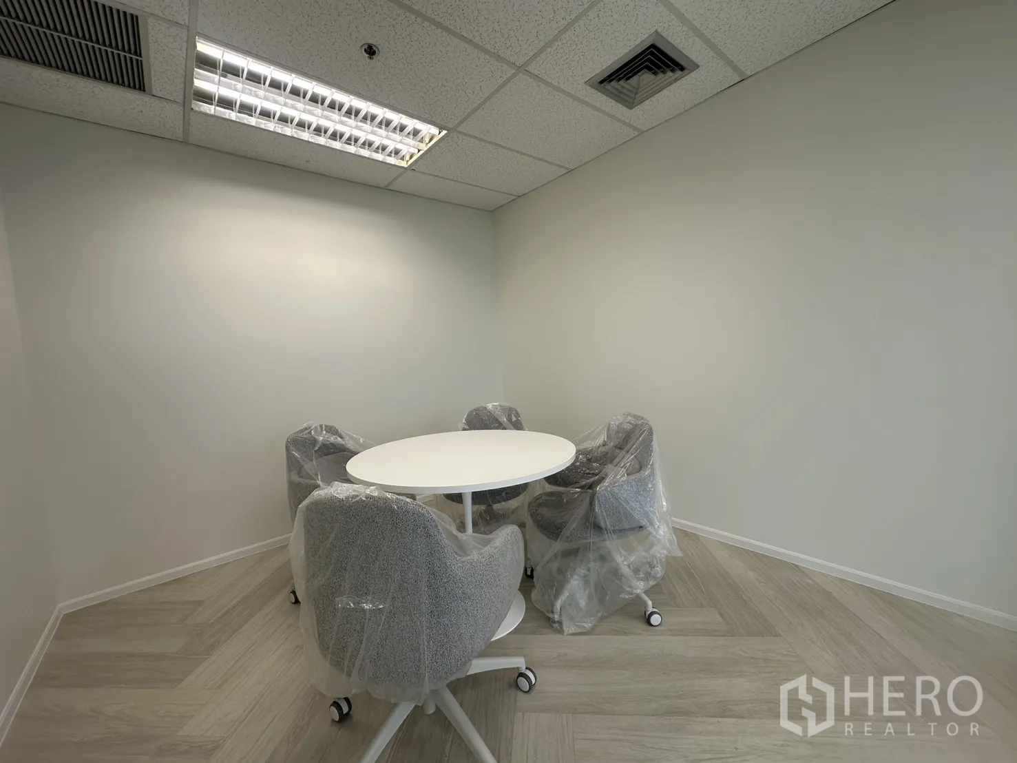 办公室 for rent in Sathon, Bangkok - 小型圆桌会议室，四把软垫椅，装饰简洁。