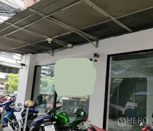 零售空间 出租在Bang Rak, Bangkok - 临街底层商铺，整面落地玻璃与金属雨棚，门前停有摩托车，位于Bang Rak城区。