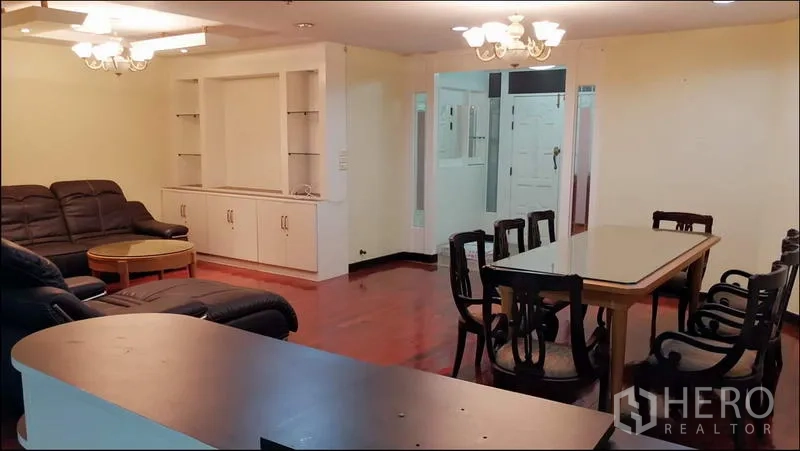 公寓 出租或出售在Khlong Toei, Bangkok - 宽敞客餐厅，皮质转角沙发，六人餐桌与嵌入式收纳柜。