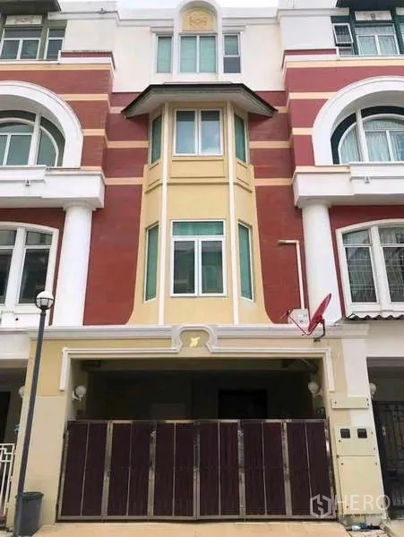 Townhouse for rent in Phra Khanong, Bangkok - Four-storey townhouse facade in red and cream with gated carport in Phra Khanong.