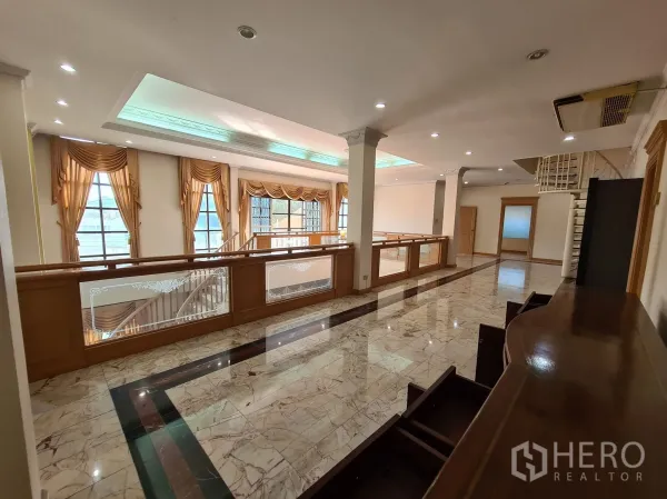 Detached House for sale in Chatuchak, Bangkok - Upper gallery with recessed lighting, marble flooring and timber balustrade.