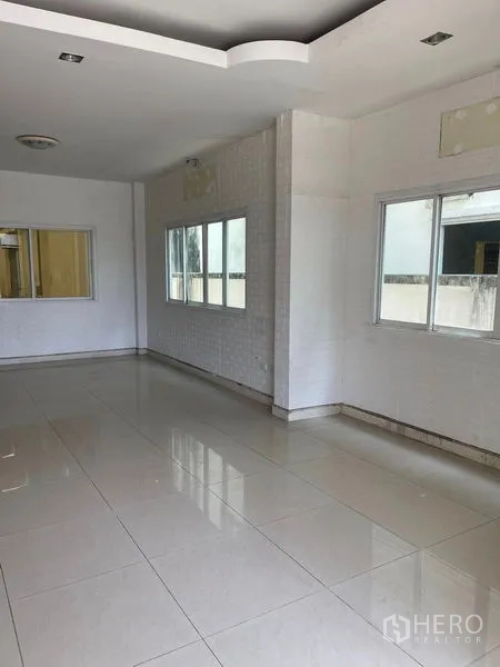 Warehouse for rent in Samut Sakhon - Open-plan office or showroom area with glossy tiles and multiple windows for natural light.