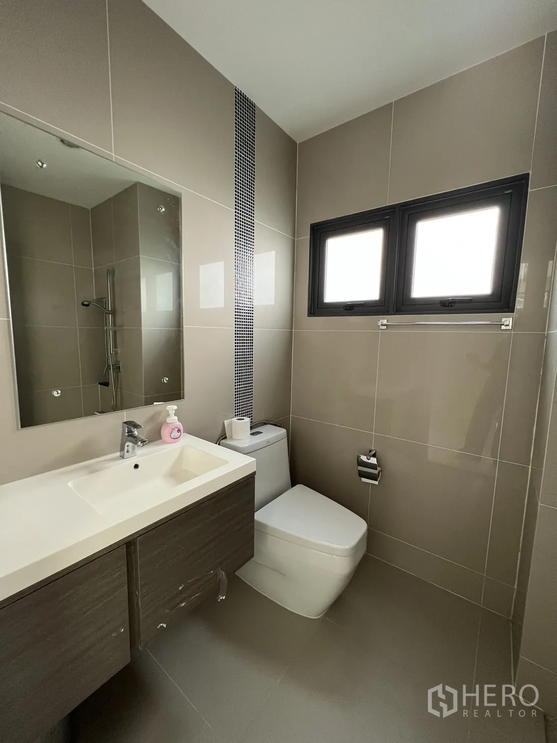 Detached House for sale in Suan Luang, Bangkok - Vanity and toilet in modern tiled bathroom with frosted window.